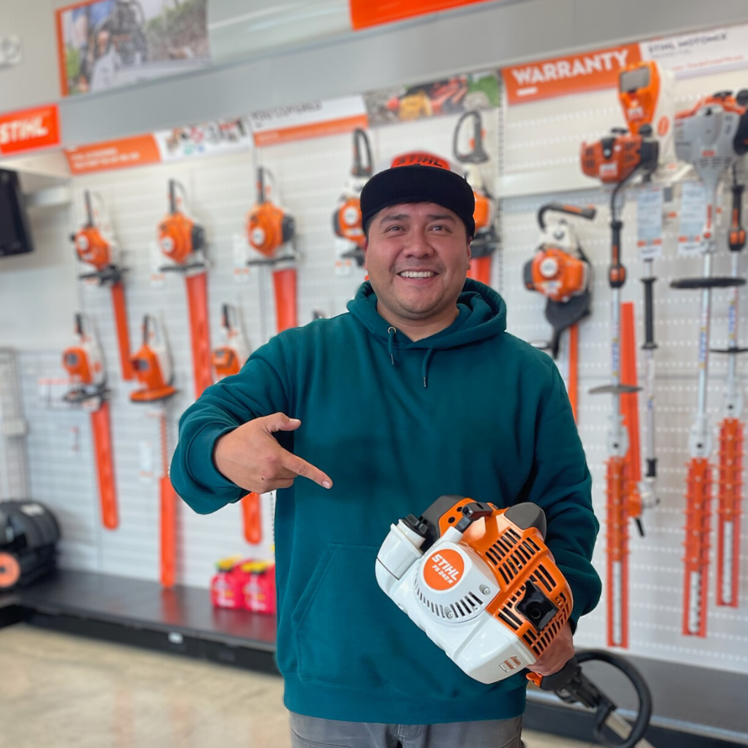 Gabe smiling holding a STIHL FS 240 trimmer