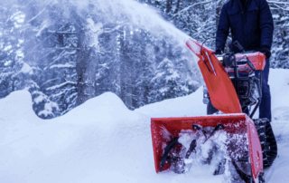 Image of a man using an Ariens snow thrower to clear snow