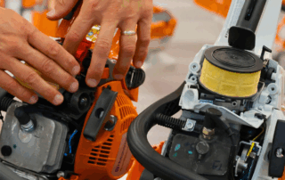 Image of someone performing maintenance on a chainsaw.